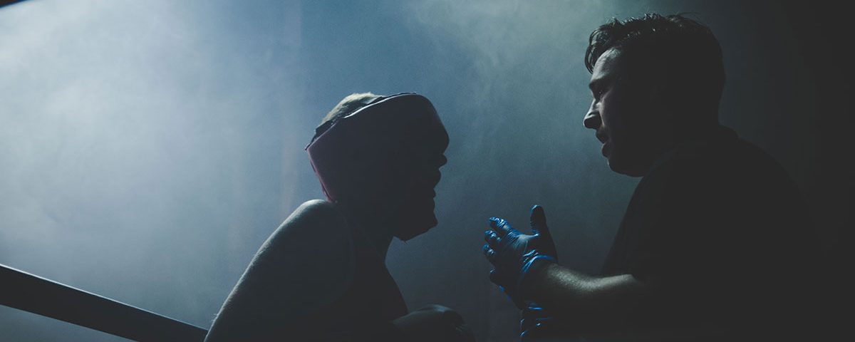 Viestinnän ammattilainen ristiriitojen ratkojana - nyrkkeilijä ja kehätuomari silhuetti kuvassa nyrkkeilykehässä